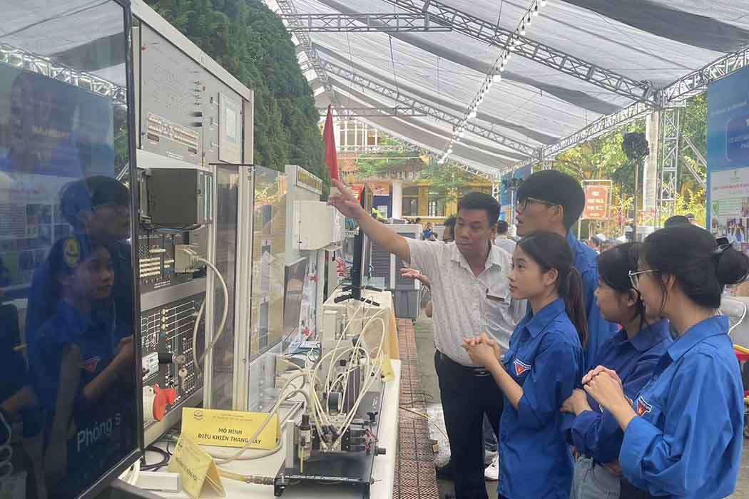 Cán bộ, giảng viên của Trường đang giới thiệu, giải đáp thắc mắc về một sản phẩm công nghệ cho các đại biểu và khách tham quan tại gian hàng